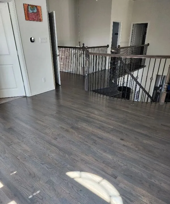 Gray-stained hardwood flooring on a landing and hallway in an Arlington, TX home